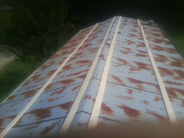 Rusted metal roof panels with new wood purlins before replacement — Storm Damage Roof Repair in Tyaskin by Roofing Brothers