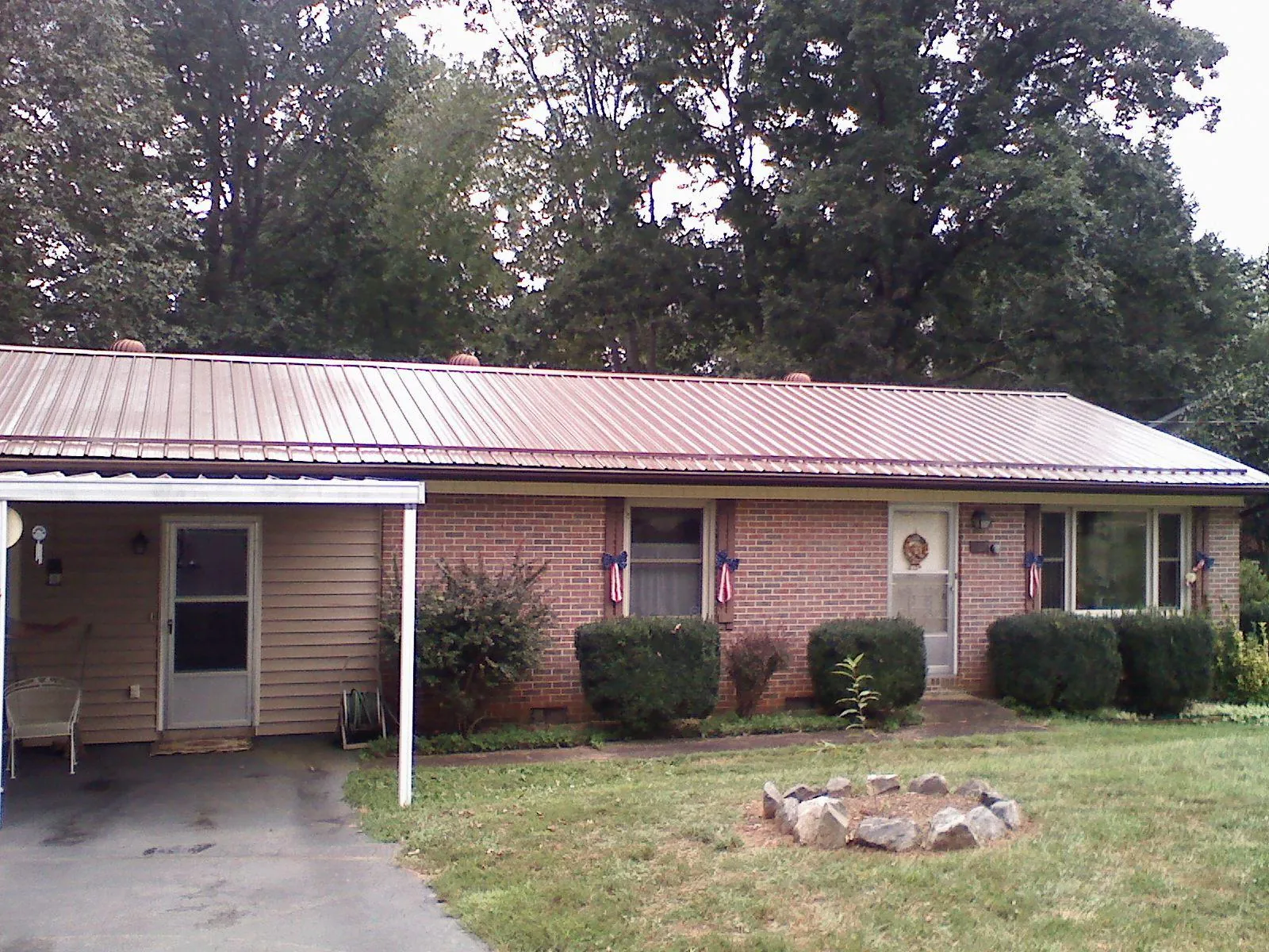 Bronze metal roof and carport on a brick ranch home — Roof Repair work by our crew in Tyaskin